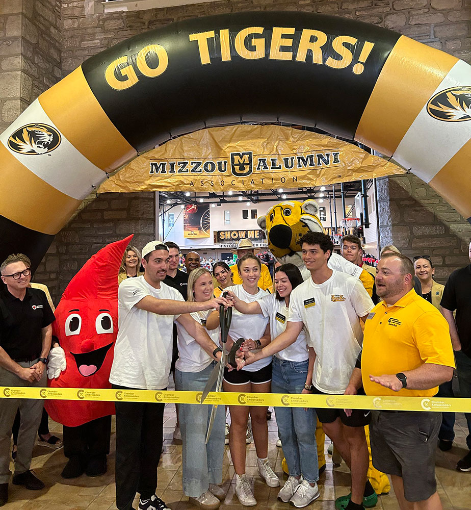 group of people, red cross blood drop mascot and Truman the Tiger mascot at ribbon cutting ceremony.