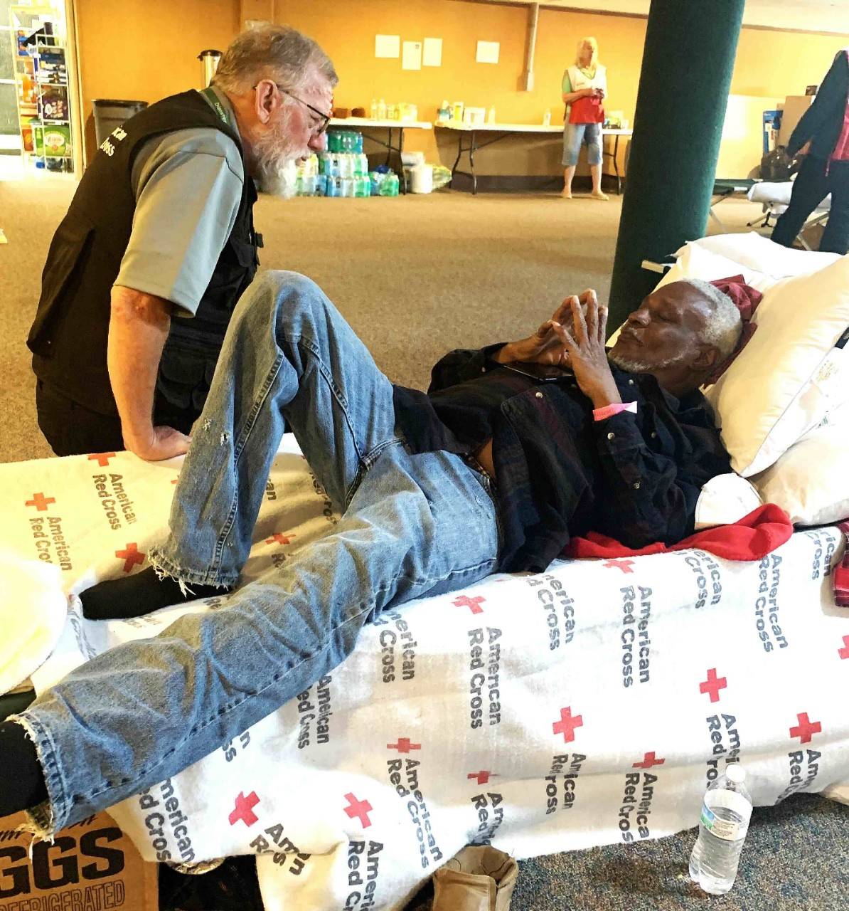 Volunteer Greg Gooch prays with Greg