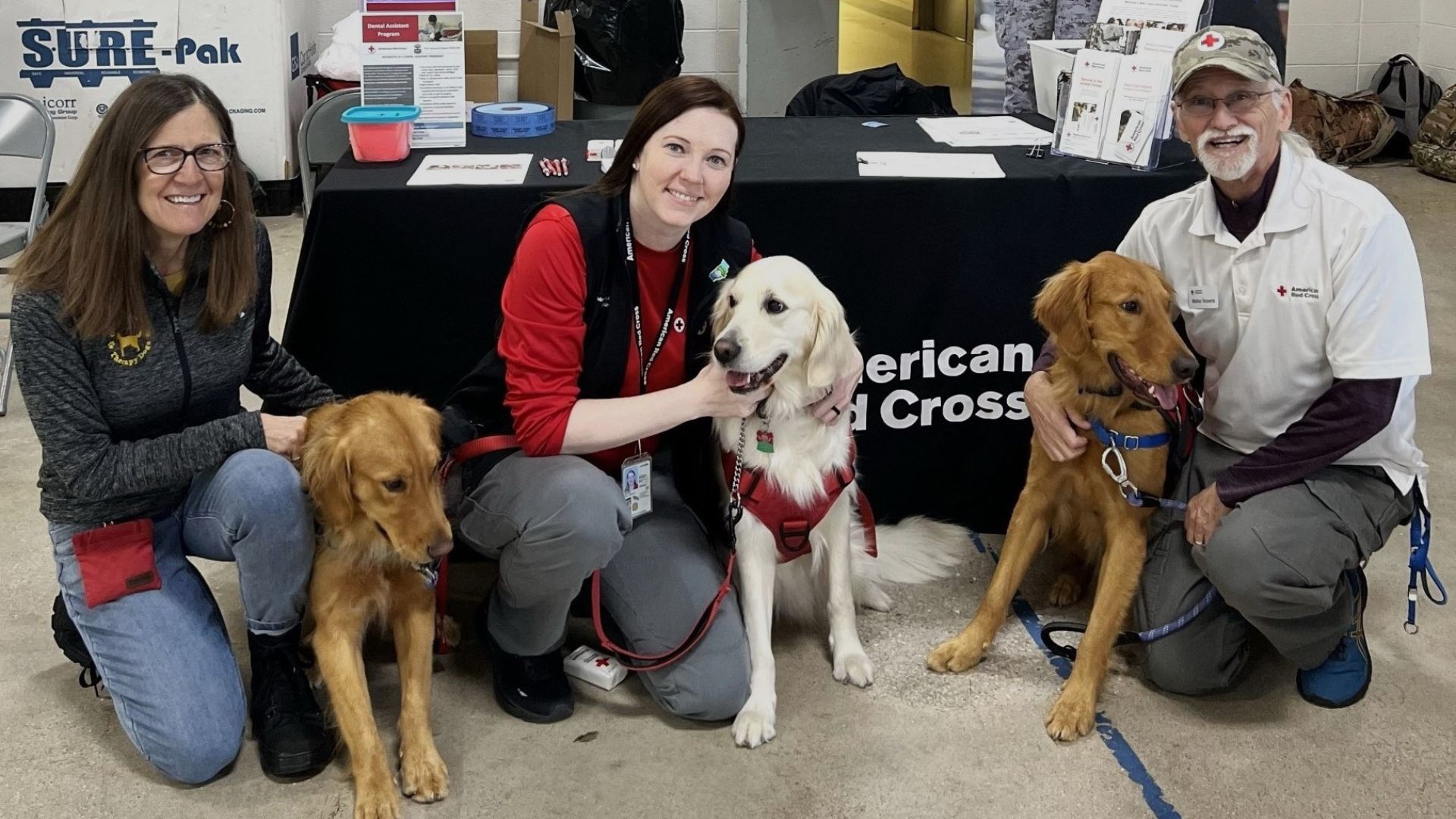 red crossers smiling with three dogs