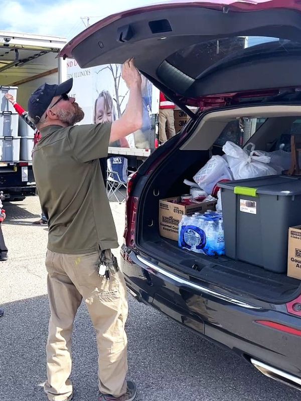 man loading the back of vehicle's trunk