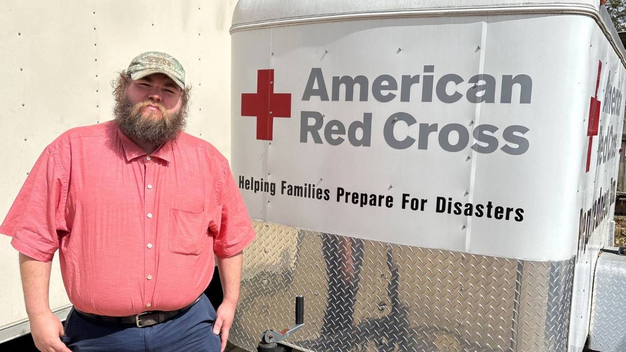 volunteer standing next to red cross truck