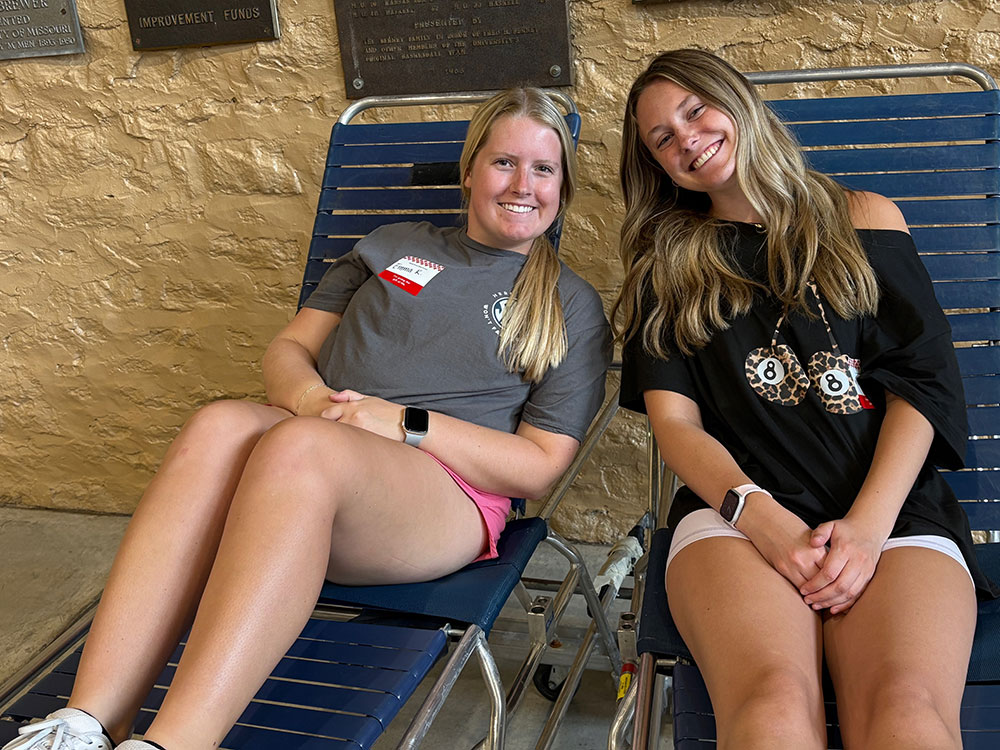 Nursing students Emma Renz and Mary Kate Rocco sitting on lawn chairs and smiling.