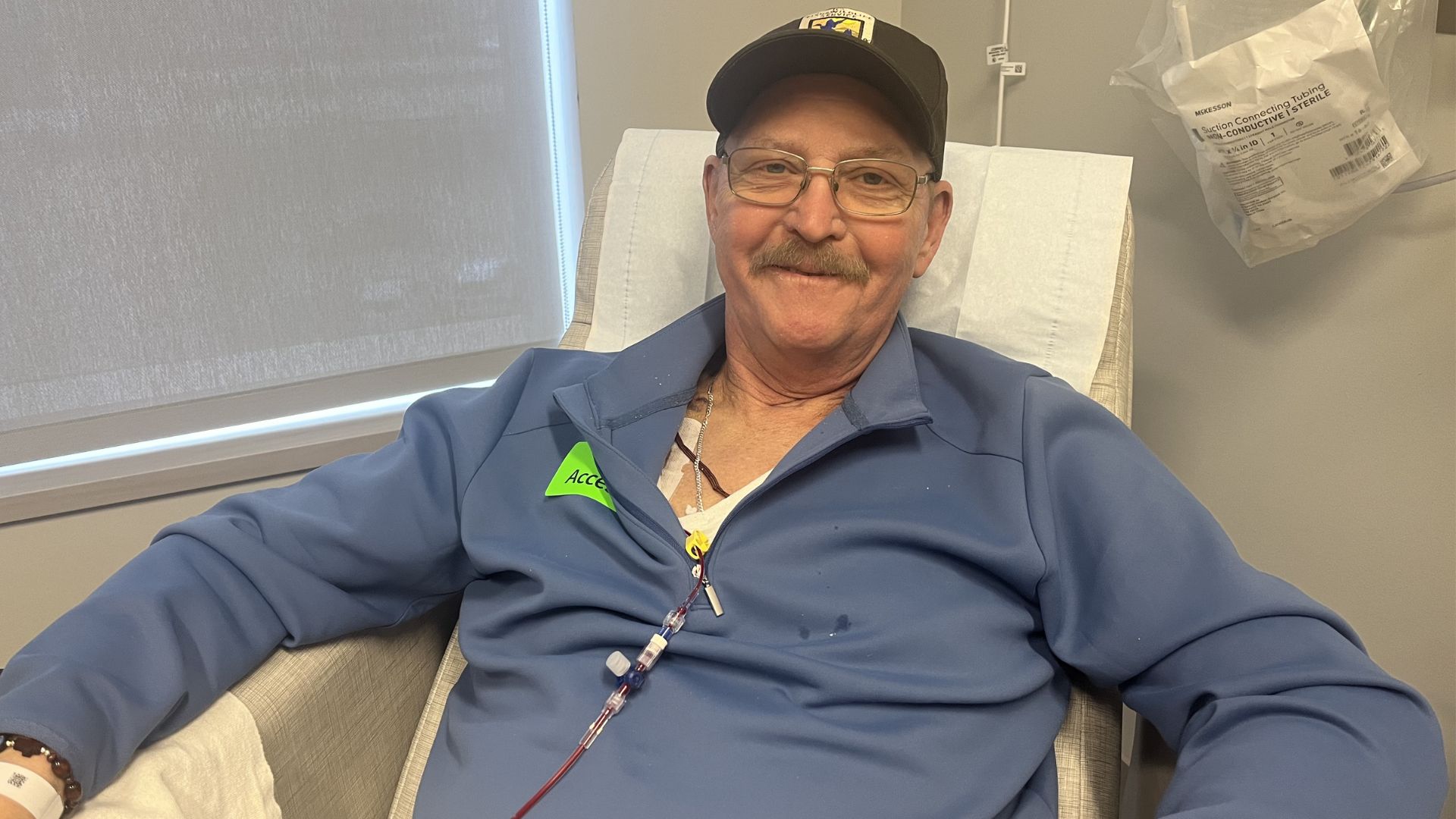 man sitting receiving blood