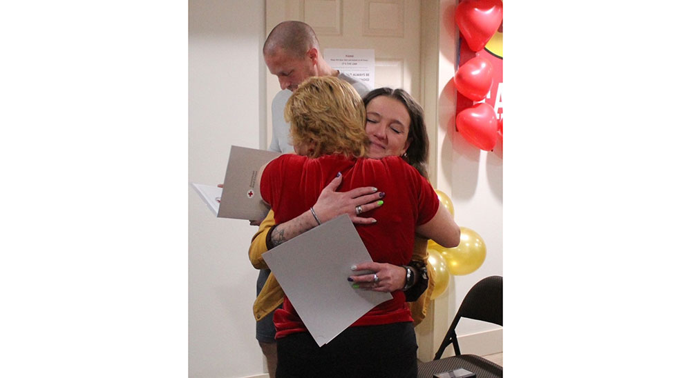 Jennifer Hardwick hugs co-worker Mayme Folio.