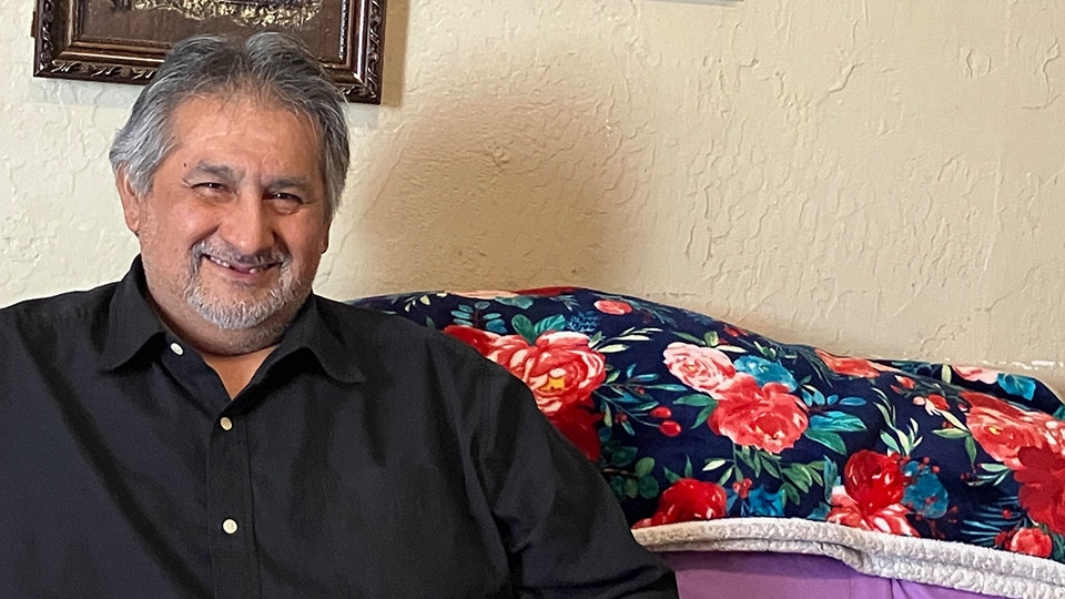 Samuel Hernandez, a victim of an apartament fire, sitting on a couch.