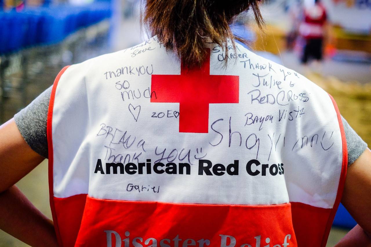 September 9, 2017. Houston, Texas. Red Cross volunteer Julie  on her first deployment working with Distribution of Emergency Supplies Group shows off the back of her Red Cross vest that children signed with messages thanking the Red Cross for helping their families recover from Hurricane Harvey. “It just put a smile on their faces,” she said adding that it was great to work with volunteers who step up to what needs to be done. Photo by Chuck Haupt for the American Red Cross