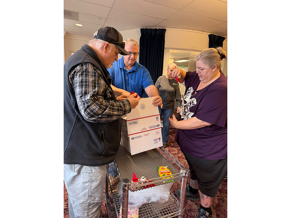 Four Red Cross volunteers putting together holiday care packages.
