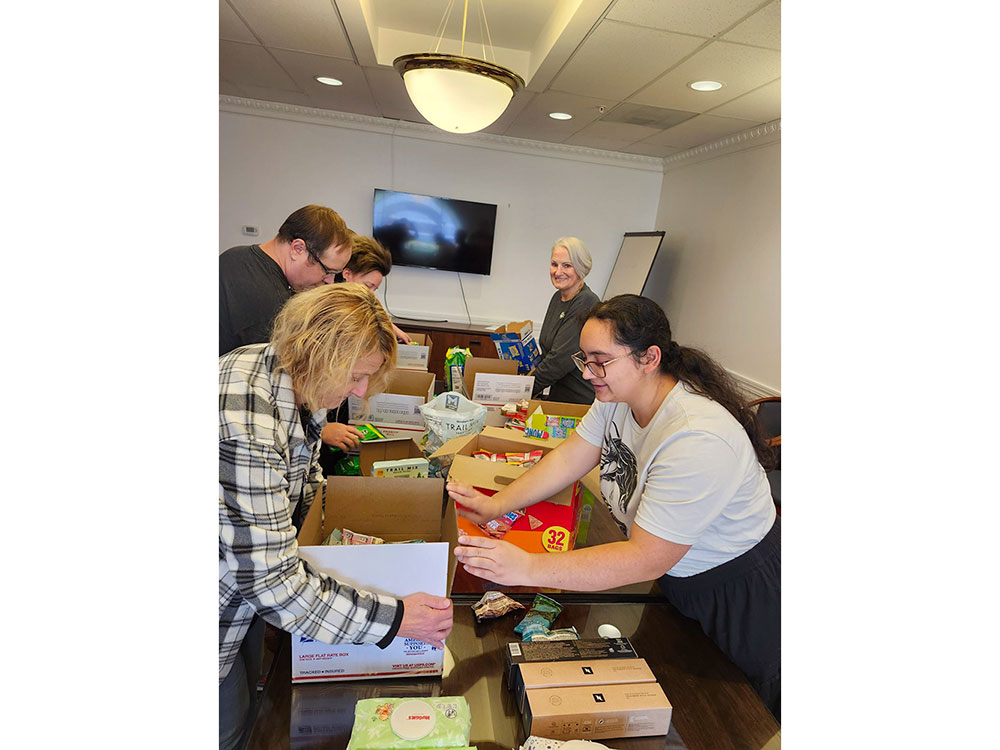 Thirteen Red Cross volunteers putting together holiday care packages.