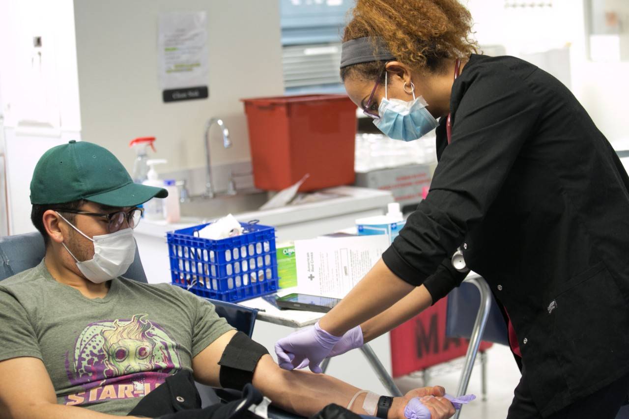 April 22, 2020. Rockville, Maryland.A Red Cross blood donor rolls up a sleeve to give blood during the COVID-19 outbreak at the Rockville Donation Center in Maryland.Photo by Dennis Drenner/American Red Cross