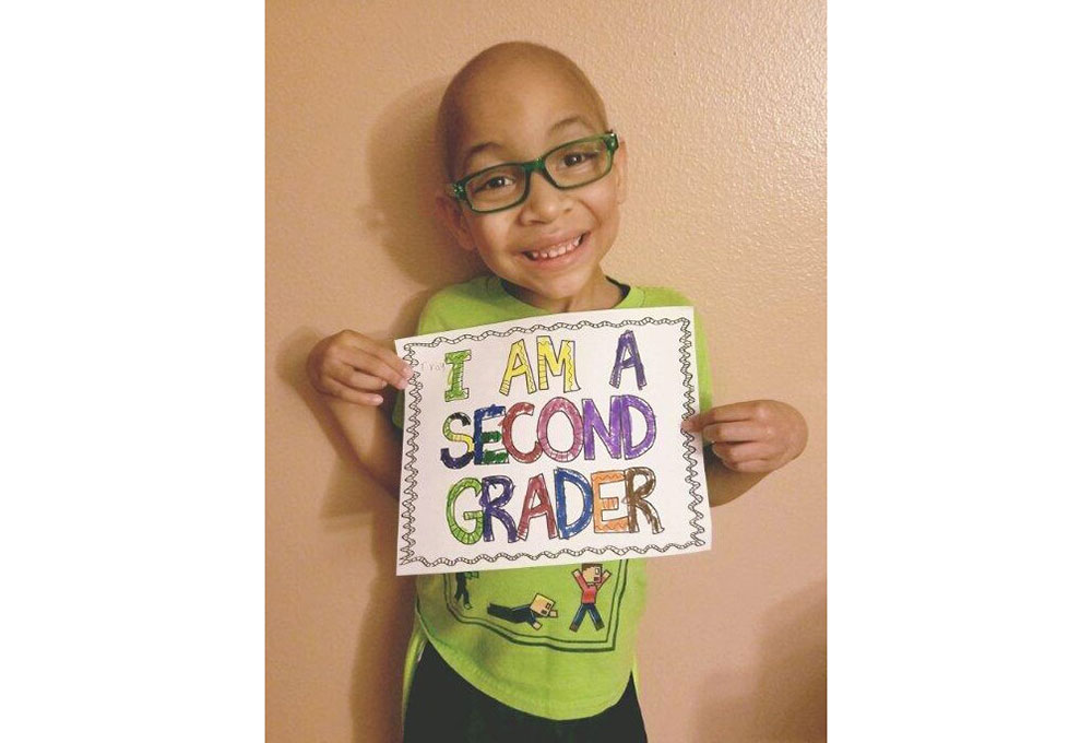 Trayson Harrell holding a sign that says, I am a second grader.