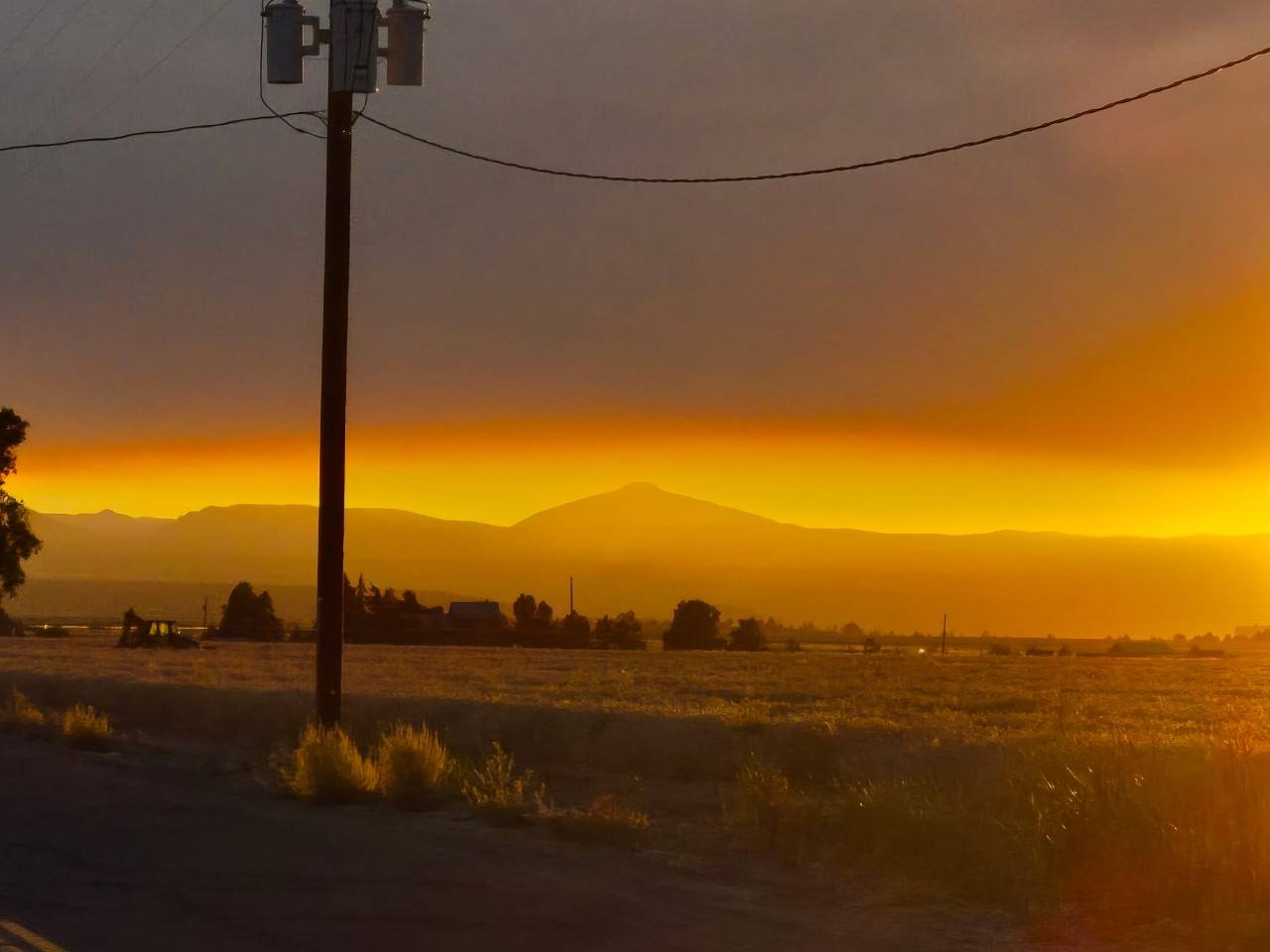 Photo of smoky landscape with mountains in the distance taken during the summer 2026 wildfires in Oregon