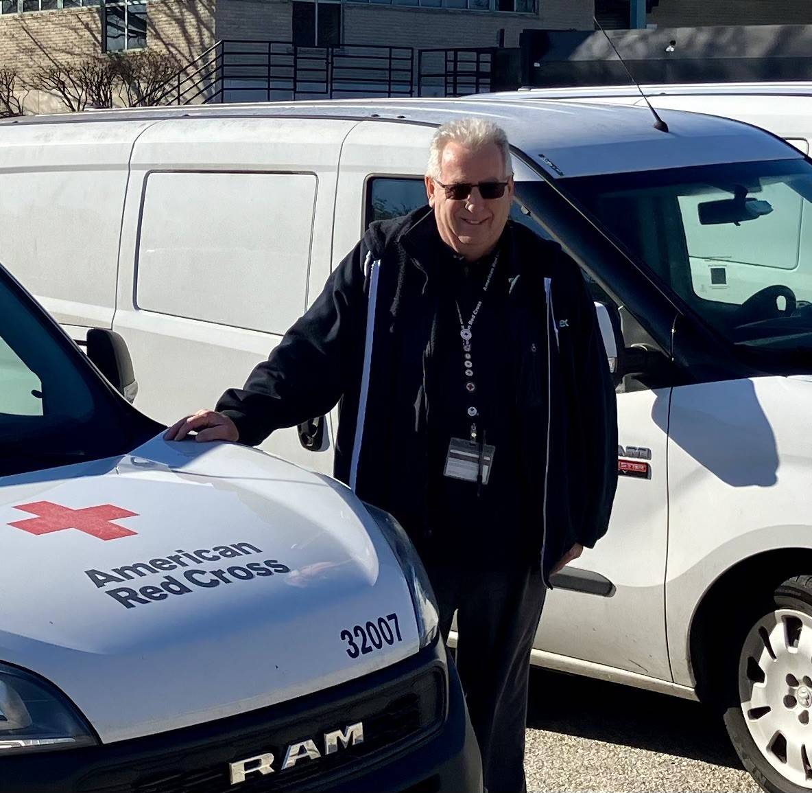 Driver Abraham Klippel in front of a Red Cross vehicle