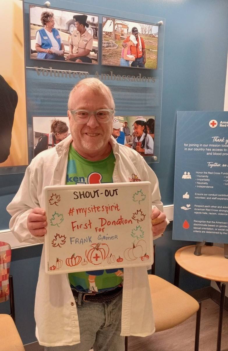 Donor Frank Gainer holds up a whiteboard