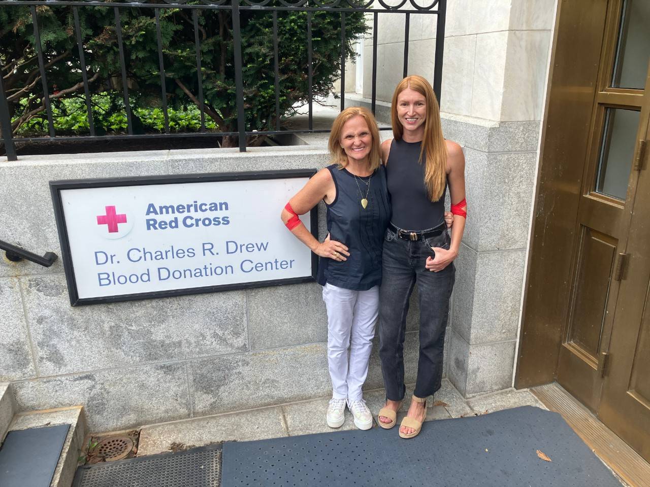 Two women blood donors stand in front of the sign outside the Red Cross blood donor center in Washington D.C.