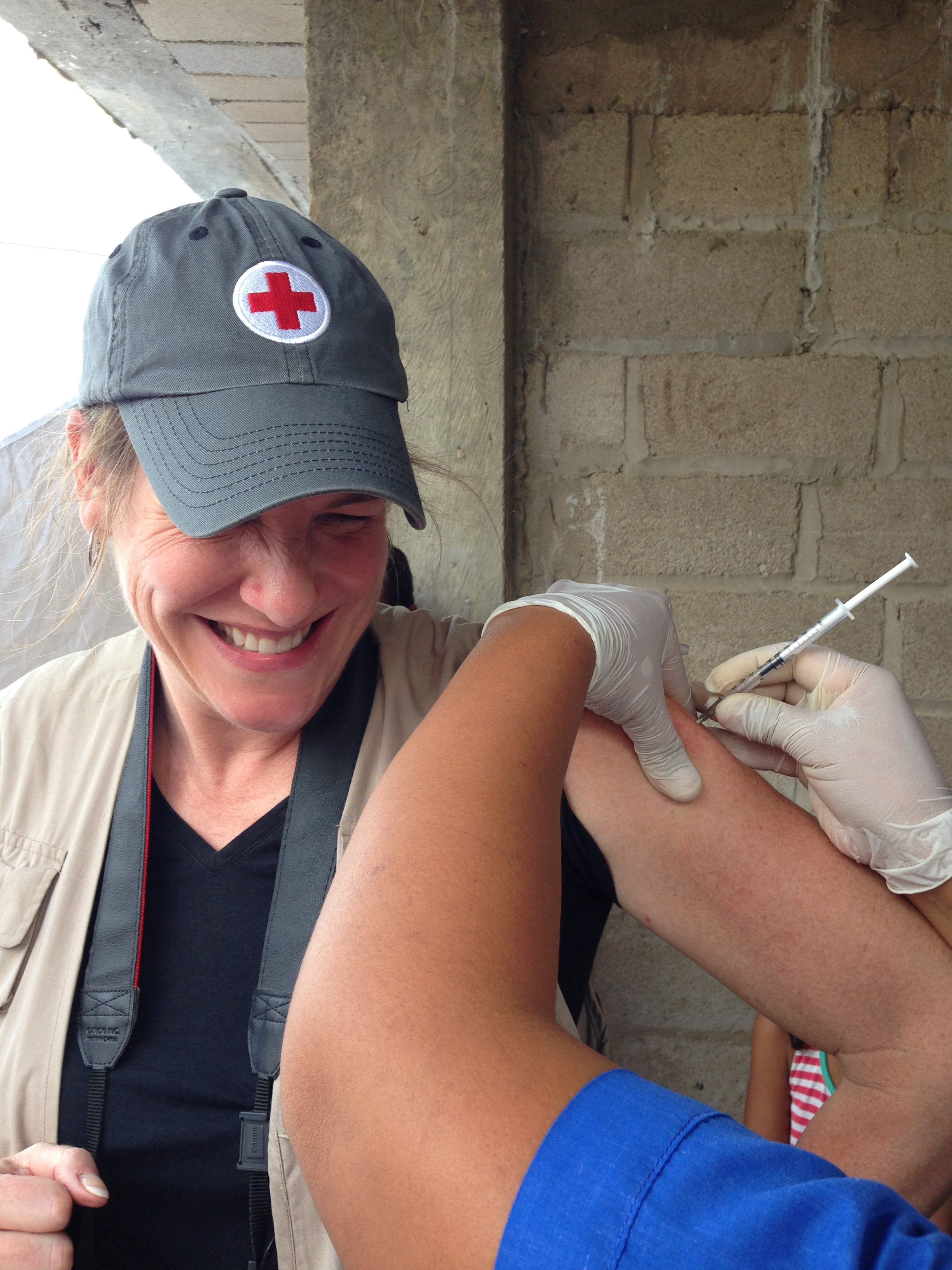 January 24, 2014. Boca Grande & La Loma, La Guajira, Colombia. Jana Sweeny receives her annual flu shot at a mobile health brigade in La Guajira, Colombia. Setting a good example for children who were nervous about being immunized, Jana decided to get the shot, which she’ll need upon return to the United States during wintertime. The Red Cross set up the mobile health brigade between two villages on Colombia’s northeastern coast, where people are regularly turned away from doctors offices and hospitals due to lack of funds. Twenty-five people from each community had the opportunity to receive medical services from primary care physicians, maternal health specialists, dentists, optometrists, as well as to receive vaccinations and pharmaceutical goods. Photo by Roberto Brito de la Cuesta  