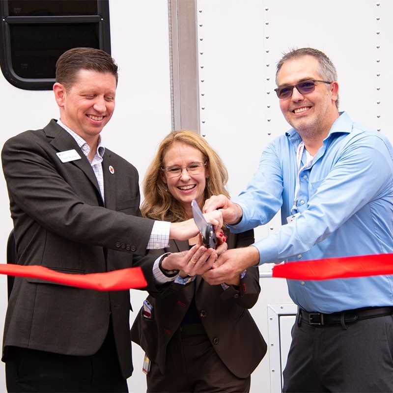 Josh Murray, Jill Orton and Travis Adams cutting ribbon at ribbon cutting ceremony.