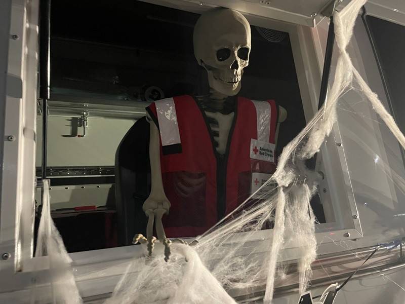 Skeleton with Red Cross vest inside emergency response vehicle