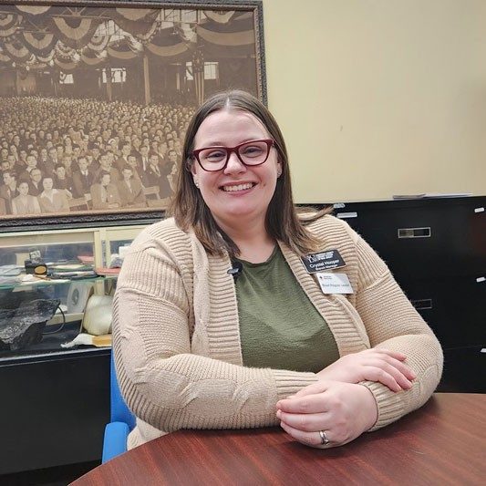 Manville Library Branch Manager Crystal Hooper sitting at a desk and smiling.