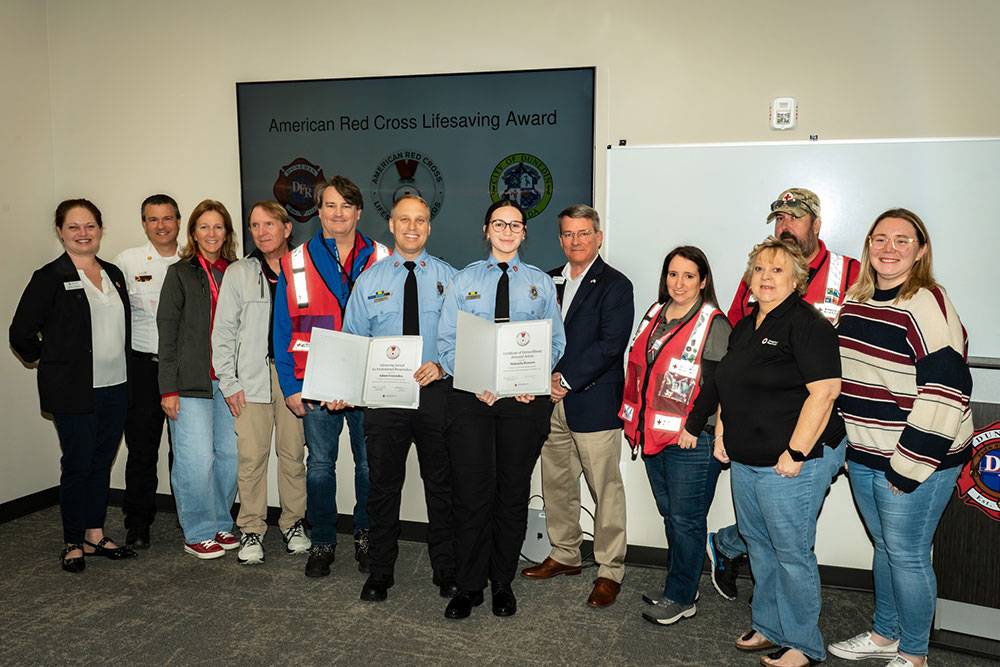 AJ Gonzales and Makayla Bowers, with a group of Red Crossers, hold their Red Cross lifesaving awards.