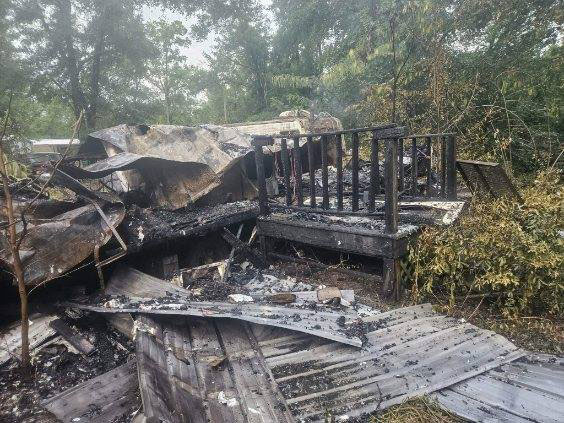 a house burned to the ground in a wooded area.