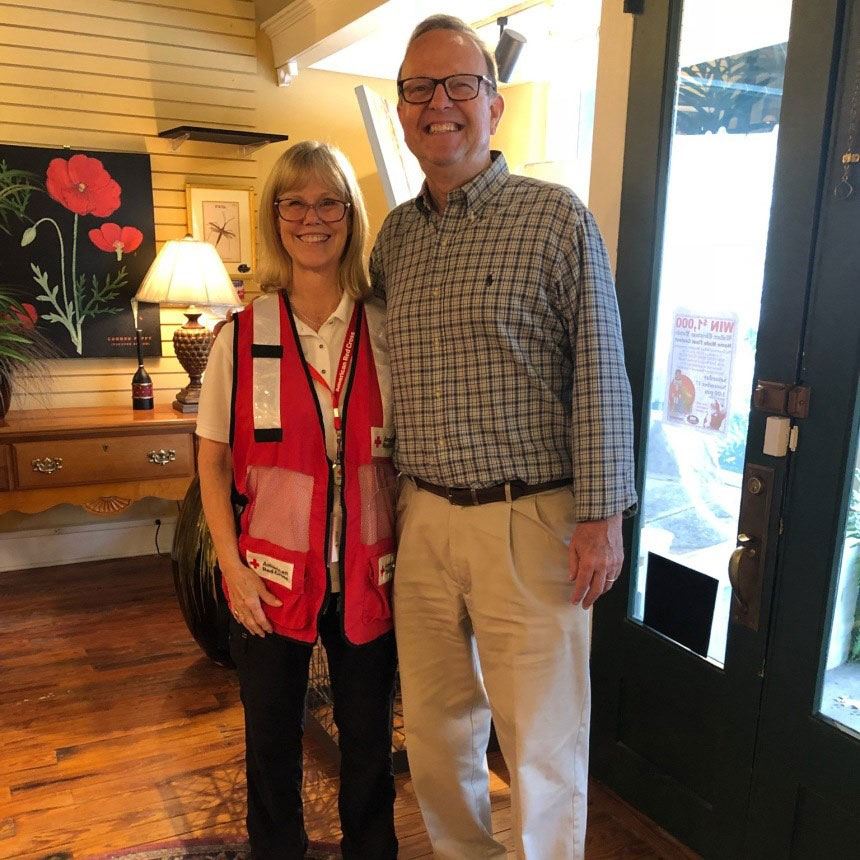 Red Cross volunteer Daryl Steinbraker standing next to a man and smiling for picture.