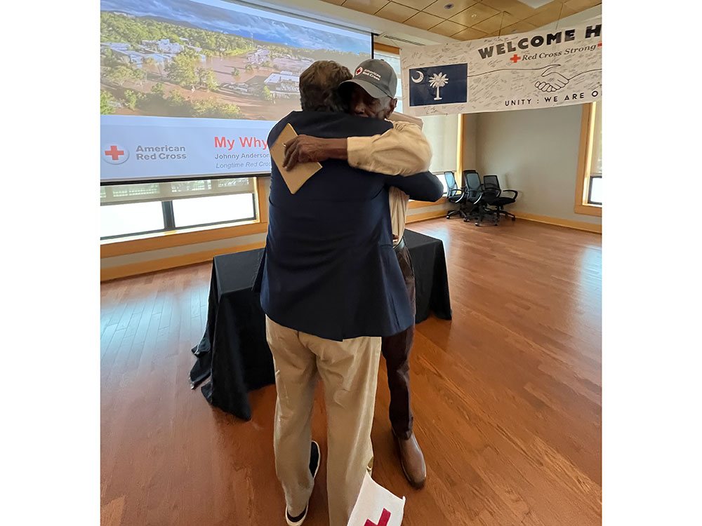 Johnny Anderson hugging a Red Cross staff member.