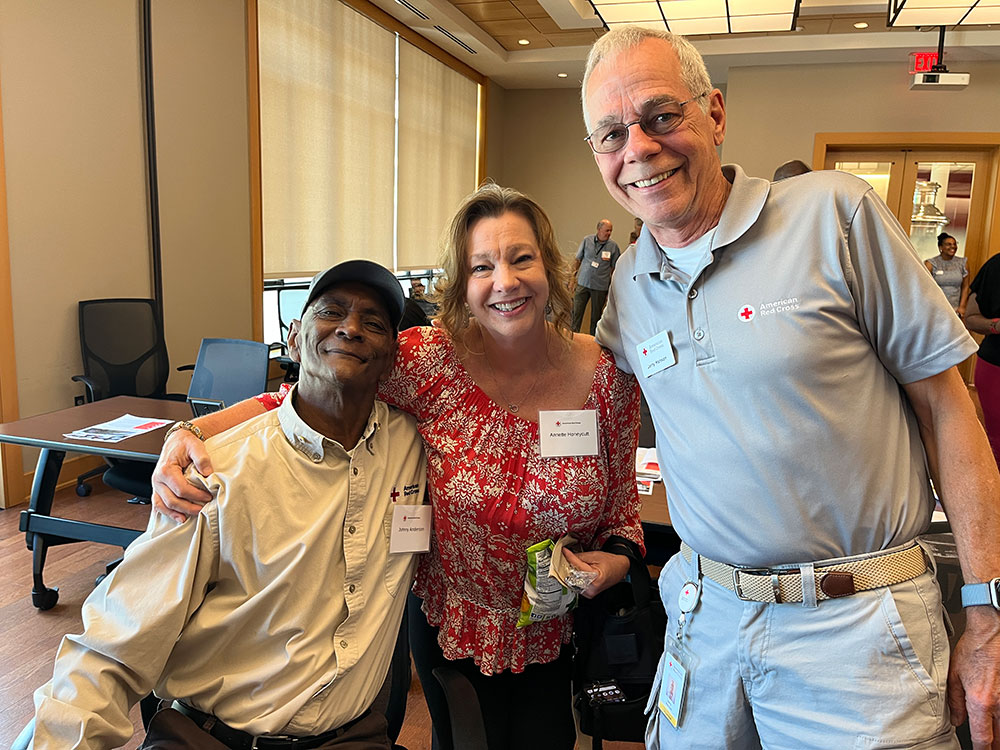 Johnny Anderson with two red cross staff members smiling for picture.