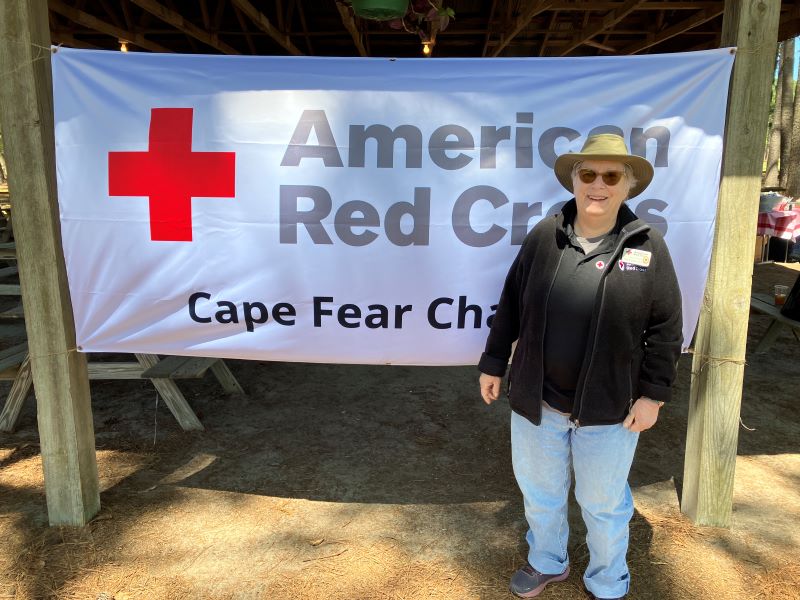 Marsha standing in front of red cross cape fear chapter sign