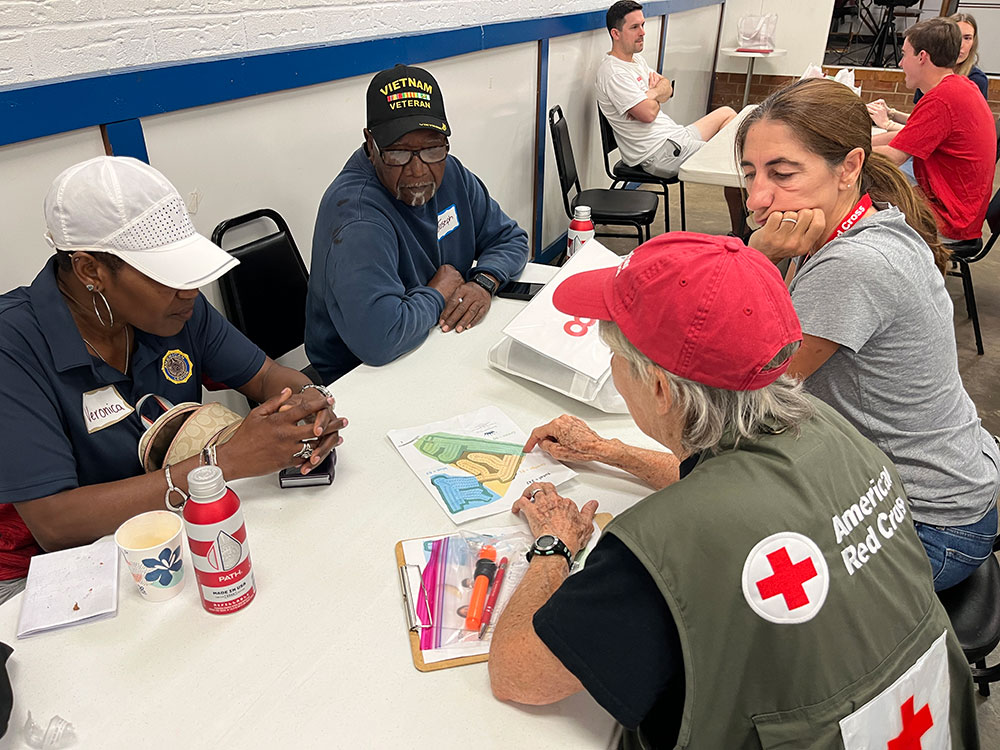 American Red Cross and American Legion volunteers plan Sound the Alarm routes while sitting at a table.