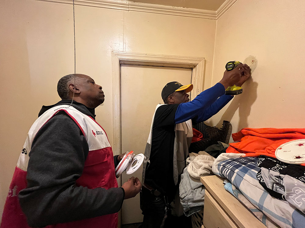 American Legion members install a free smoke alarm in Charlotte for Sound the Alarm.