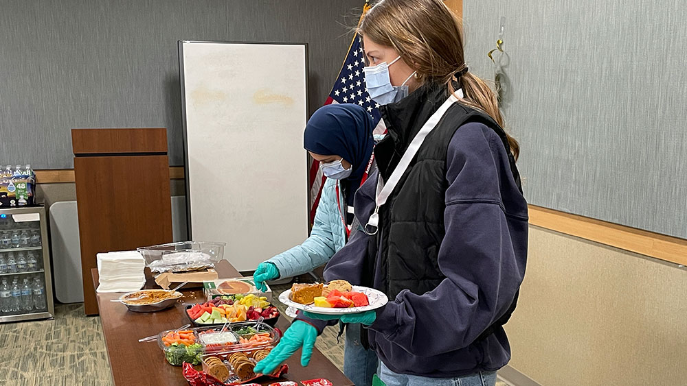 Red Cross HS Club members wearing masks and gloves and serving food. 