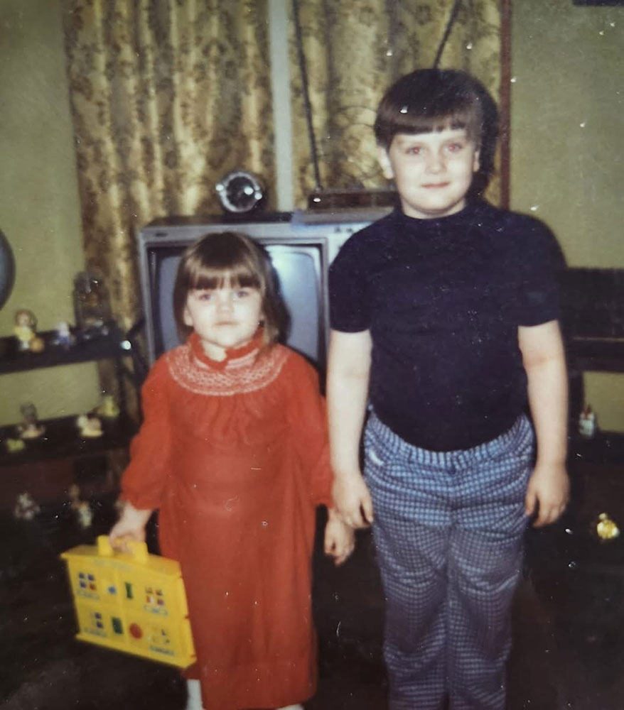 1970's pic of young brother and sister in a room with a tv.