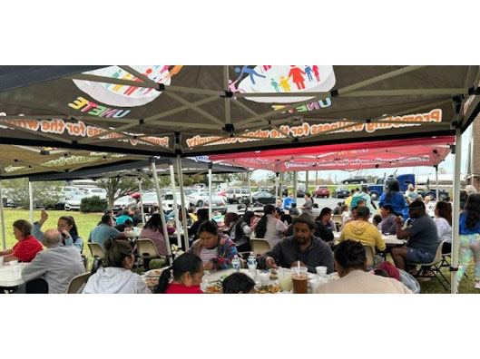 people eating at tables that are under canopies.