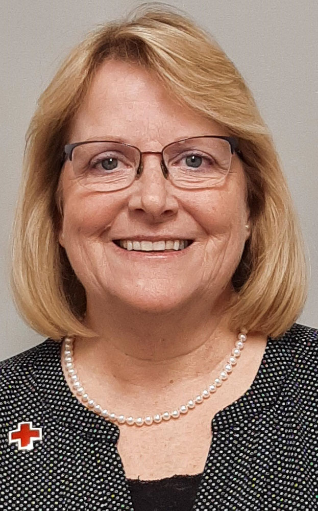 headshot of Tammy Forrester wearing glasses, necklace and a Red Cross pin.