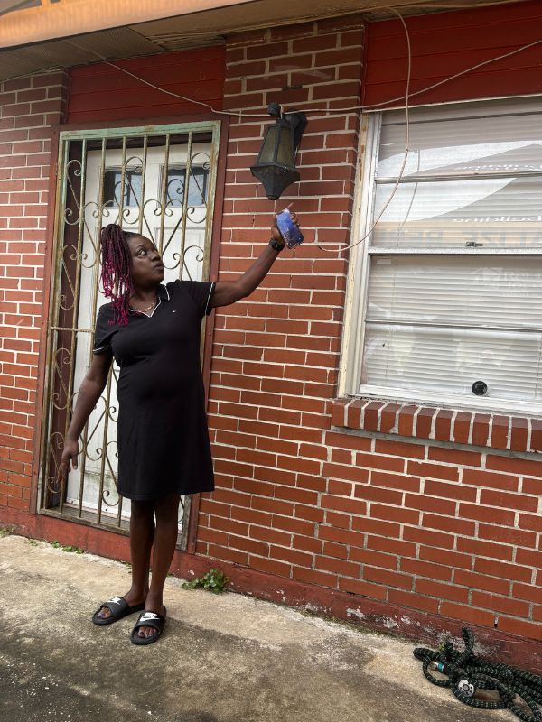 woman viewing damage on outside of home