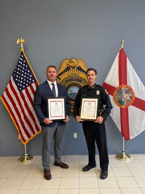 two police officers holding award.