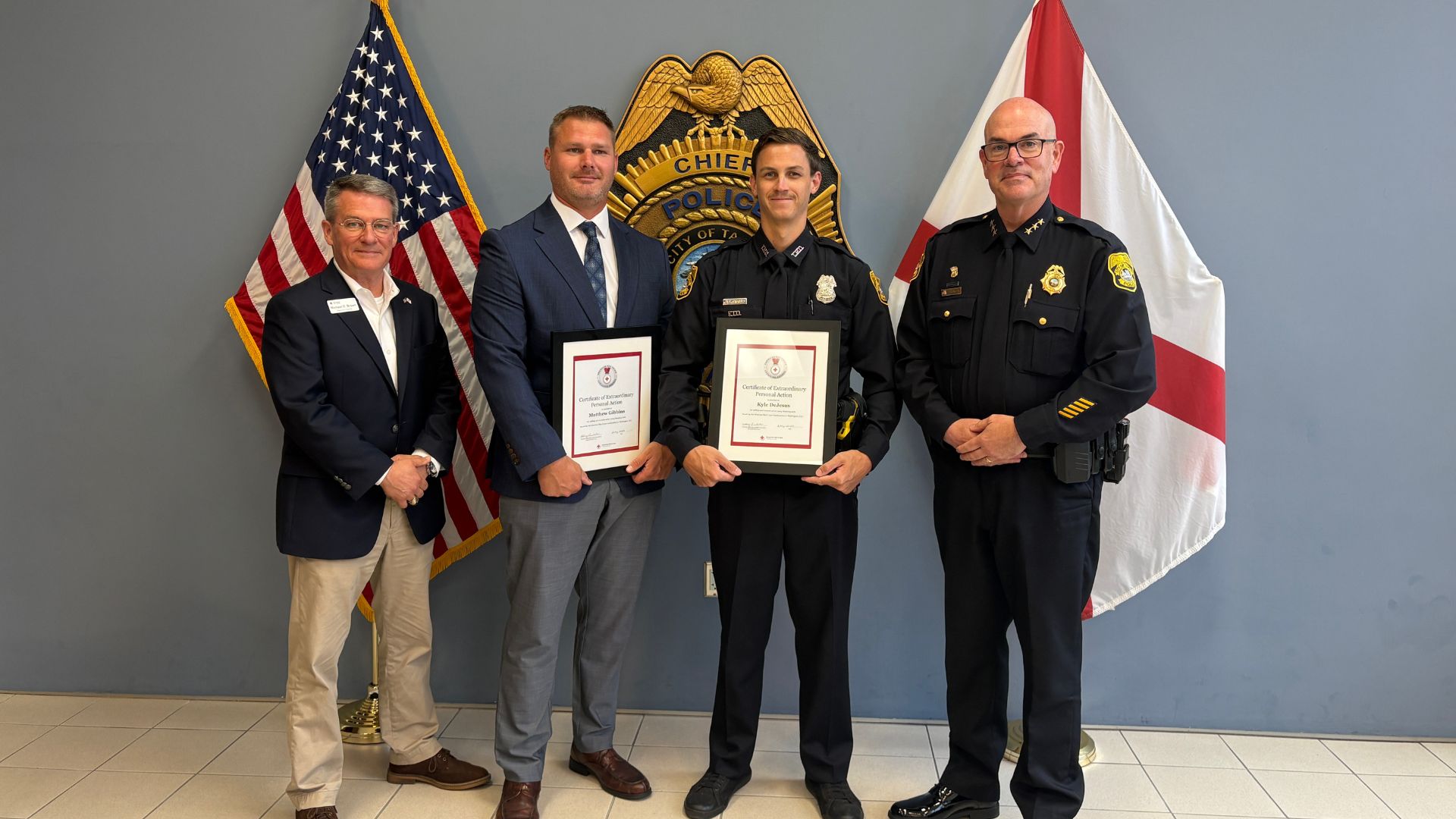 police officers standing with two men receiving award.