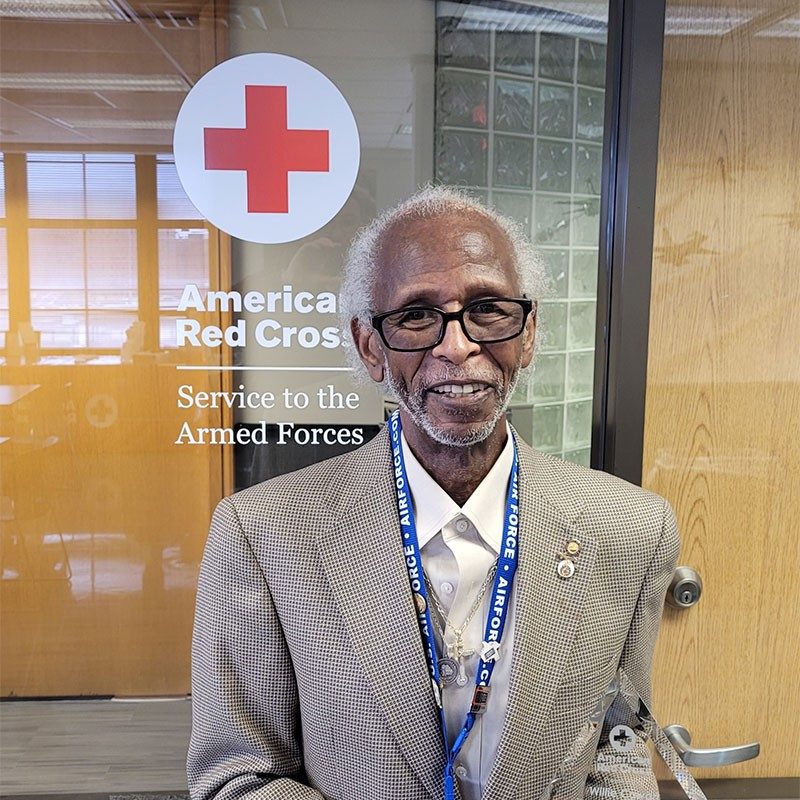 Willie Cowart in front of Red Cross glass door smiling for camera