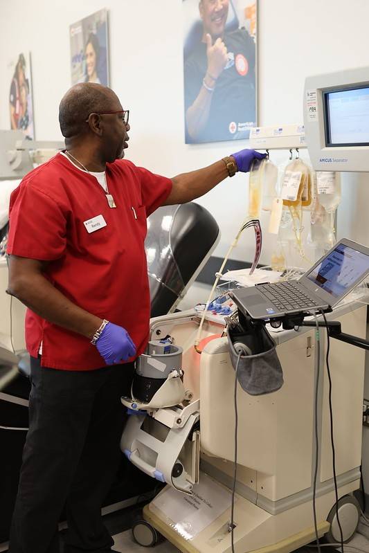 a person in red scrubs hanging medical equipment 