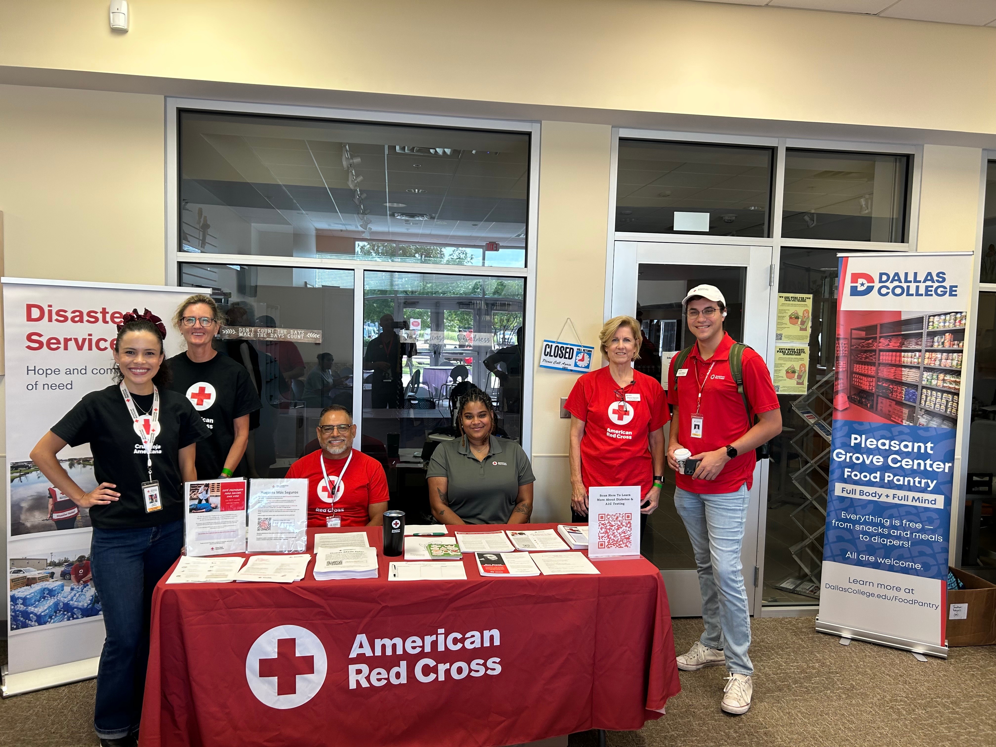 red crossers at information table with banners