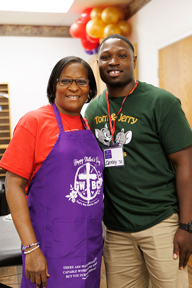 Deanna Hinton wearing an apron and Derry Jr. standing next to her.