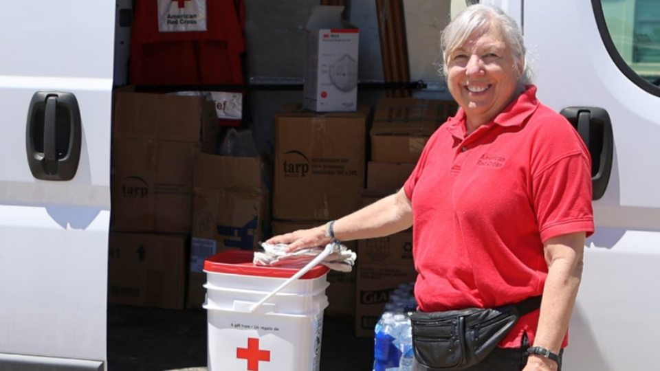 red crossers at information table with banners