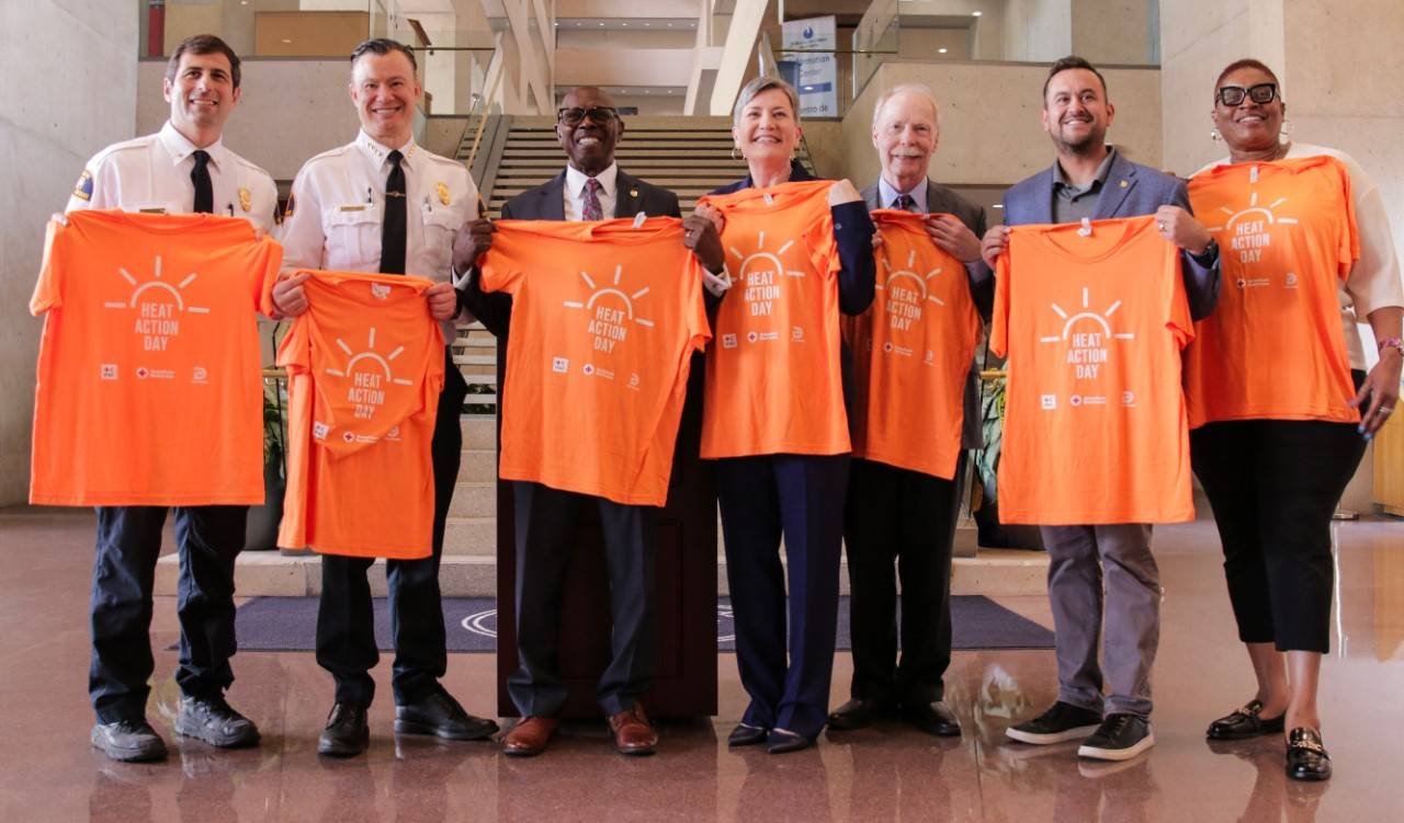 Group photo at Dallas City Hall of the American Red Cross, Dallas Fire-Rescue, elected officials, the Office of Emergency Management, and other partners holding Heat Action Day t-shirts.