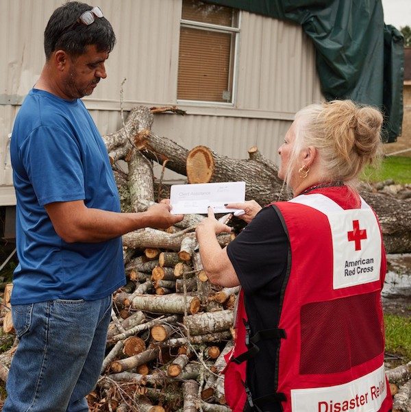 Red Cross volunteer discussing client assistance with a disaster victim.
