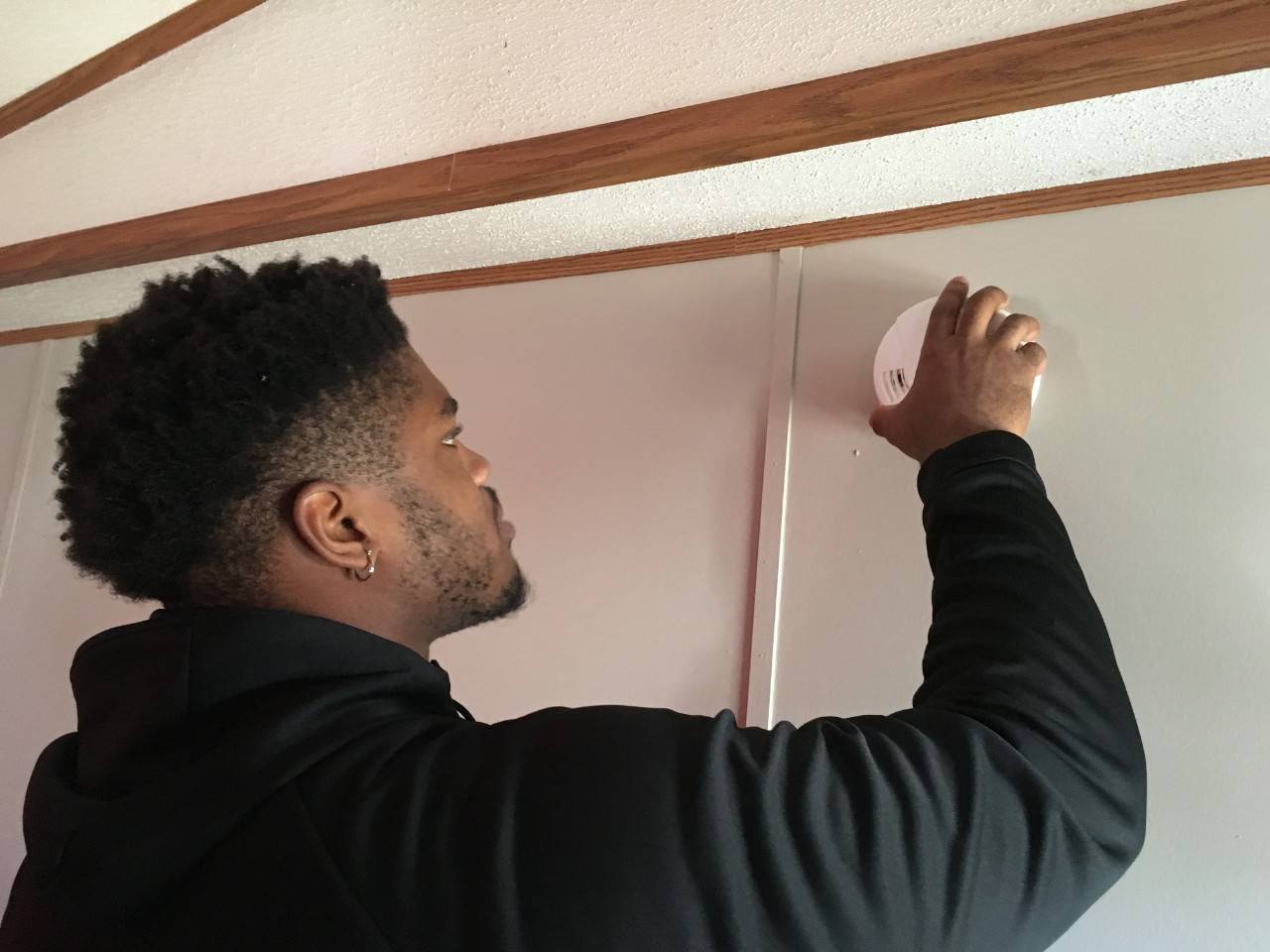 Jerard Carter (DE, Senior, Houston) installs a free smoke alarm Thursday as part of his participation in the Red Cross Sound the Alarm home fire safety event. 