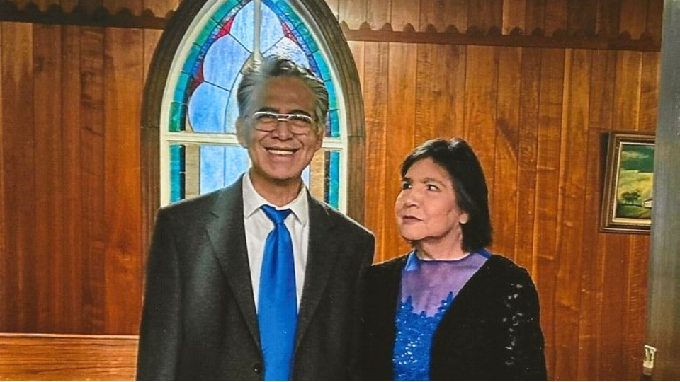 a man and woman in church clothes holding each others hand.