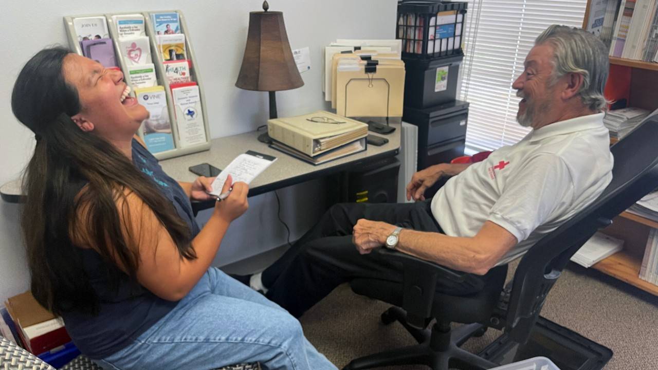 Joseph Misek, a 52 year Red Cross volunteer interviews with Eli Hernandez, a new Red Cross intern who is laughing histerically.