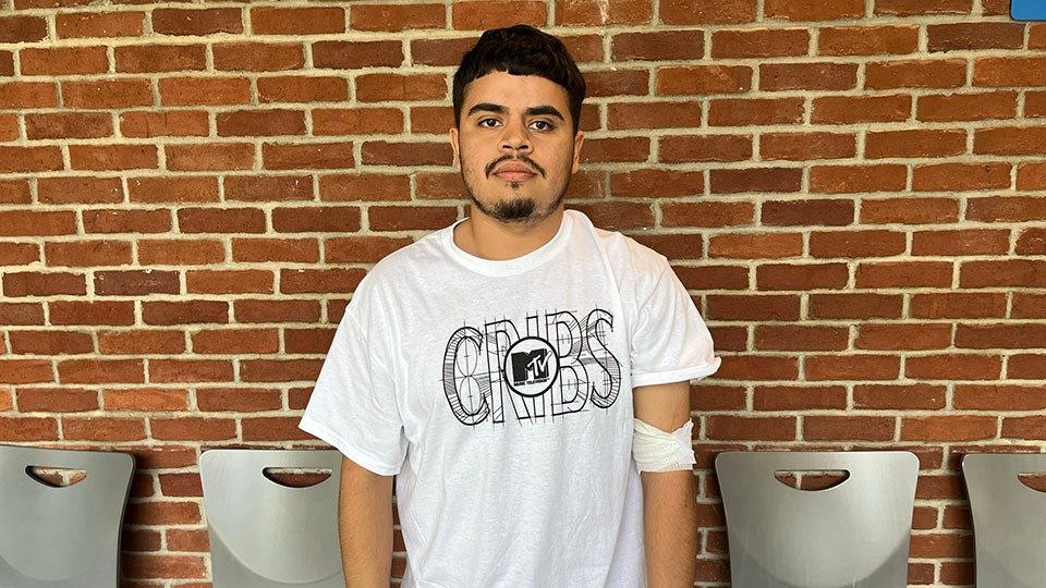 juan acosta standing in front of brick wall