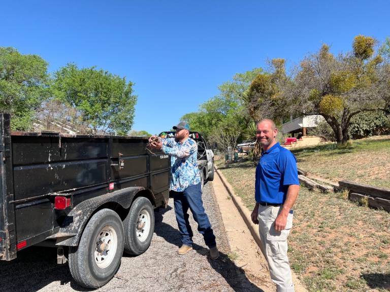 volunteers standing next to trailer connected to a truck.