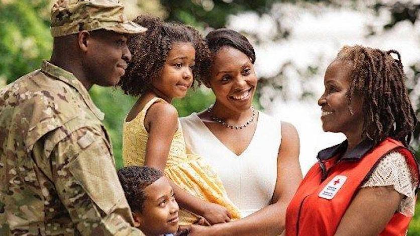 Military member, woman, two children and Red Cross volunteer